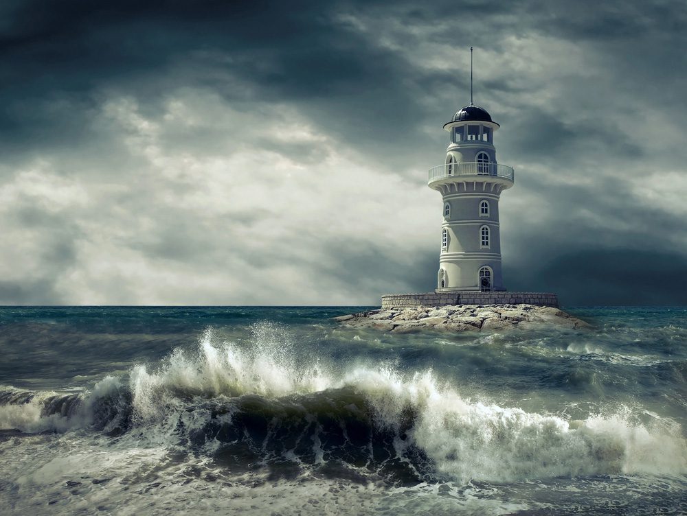 Stormy waves crashing with lighthouse in background and dark skies - Executive Leadership Coach Business Career in Pennsylvania Donna Spina Coaching InDeed